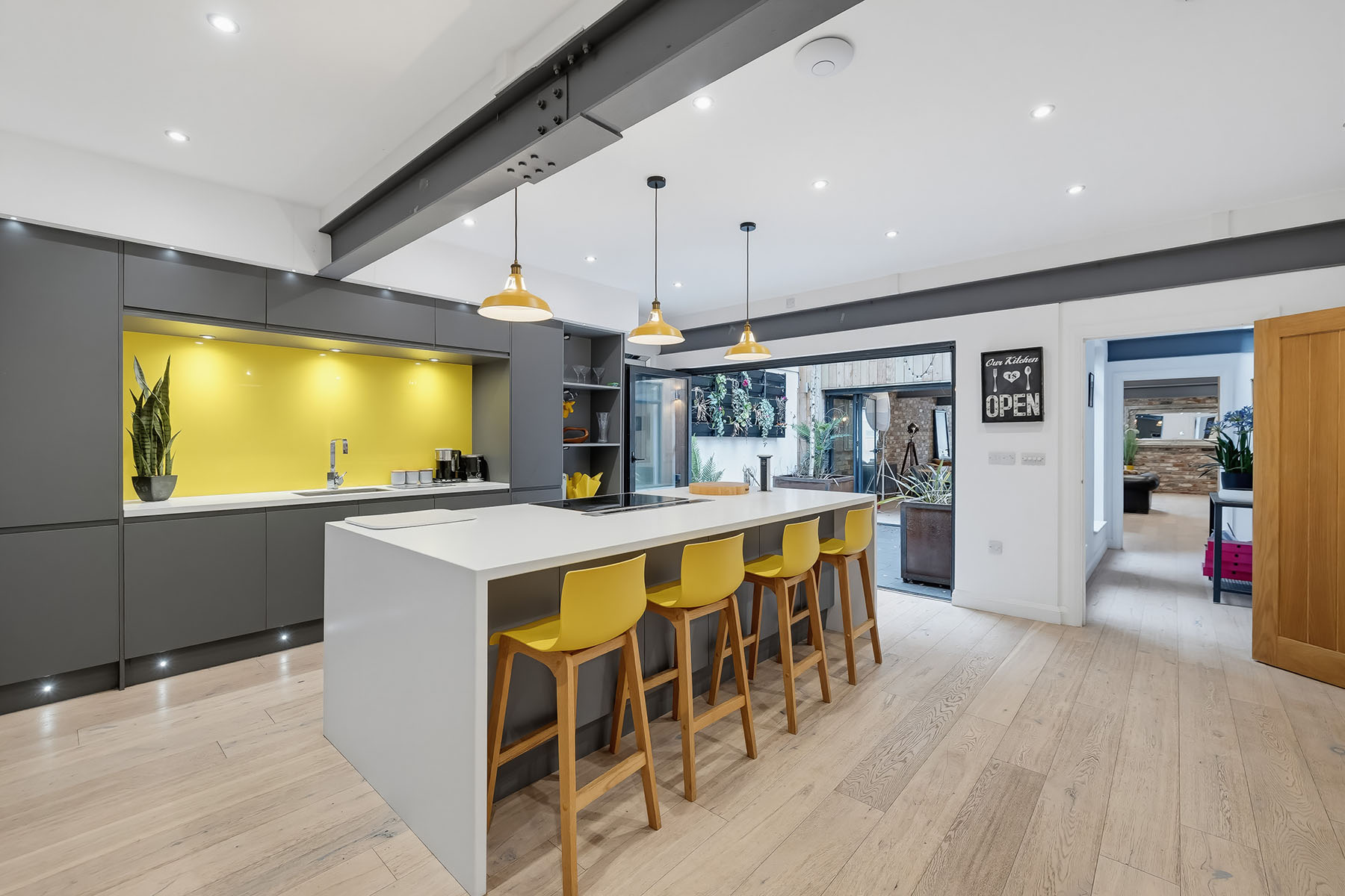 Modern kitchen photographed by 241Photography with clear worktops, breakfast island and yellow bar stools