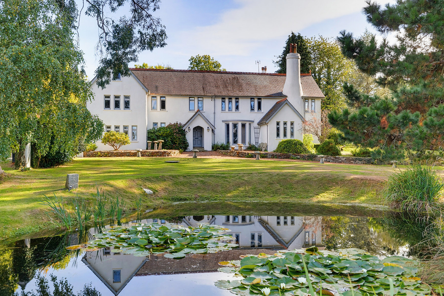 Professionally photographed house and landscaped garden reflected in a pond