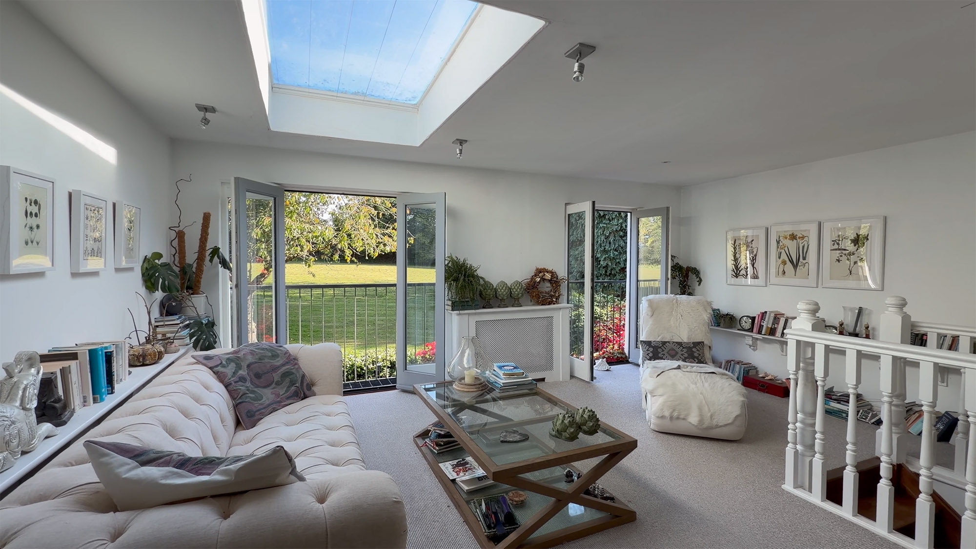 Property video still showing a bright living room with skylight, open doors and a view of the garden
